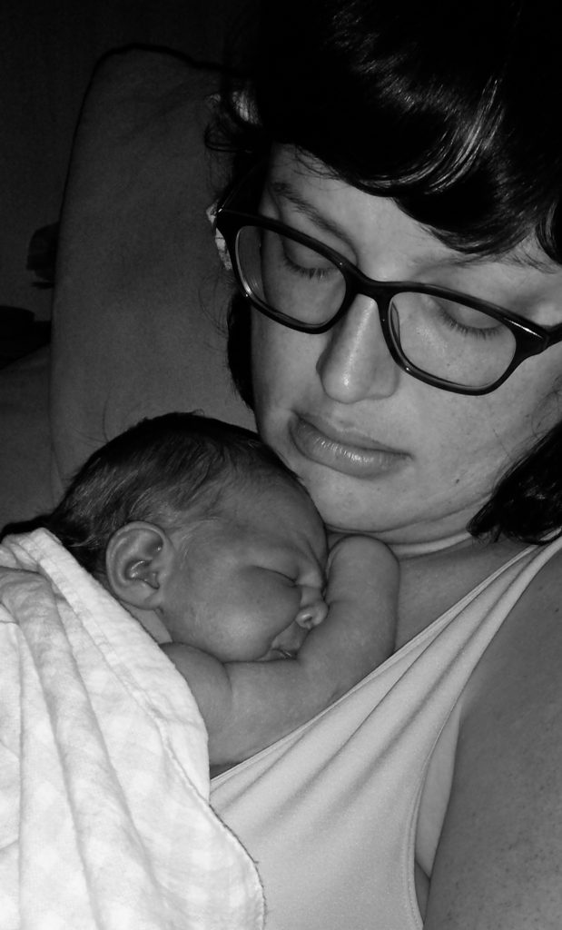 2 week old baby sleeps on mother chest. Without the ACA Obamacare I might not have had children.