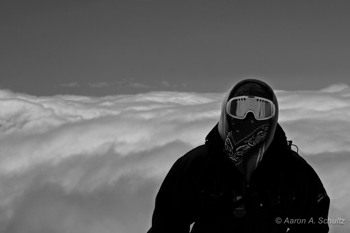 A snowboarder on a mountain seems to floats above the clouds. Mount Hood, Oregon.